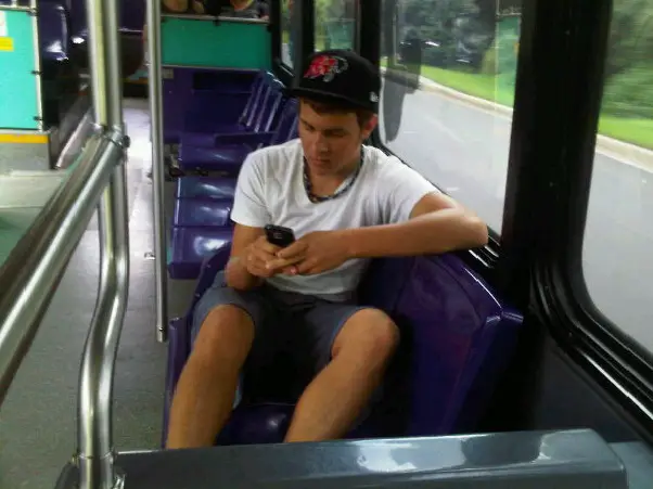 teen texting on Walt Disney World bus